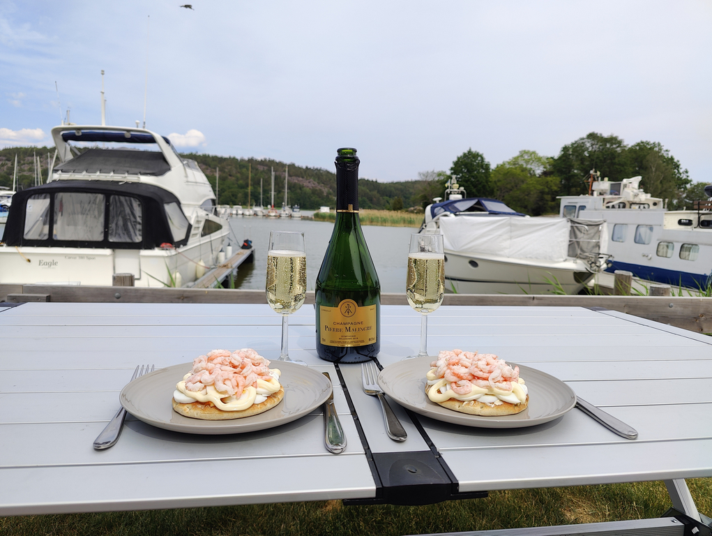 Räkmackor och champagne samt utsikt mot hamnen.